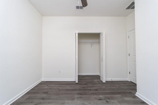 unfurnished bedroom featuring a closet, ceiling fan, and dark wood-type flooring