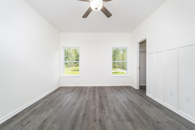 unfurnished bedroom featuring dark hardwood / wood-style floors, multiple windows, and ceiling fan