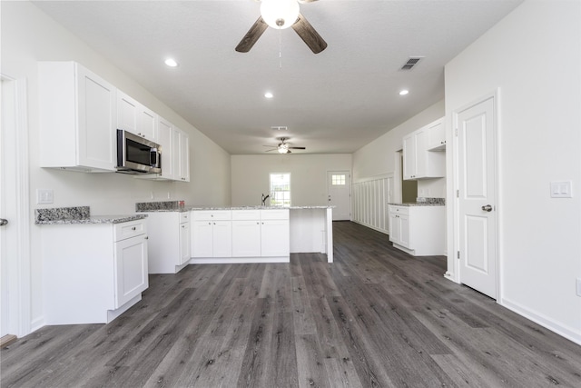 kitchen featuring ceiling fan, sink, white cabinets, and dark wood-type flooring