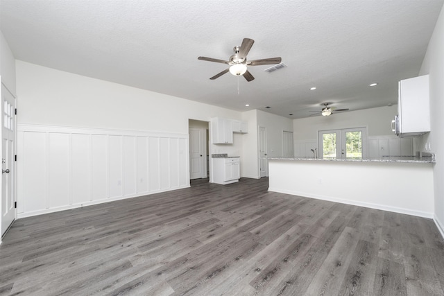 unfurnished living room with french doors, dark hardwood / wood-style flooring, a textured ceiling, ceiling fan, and sink