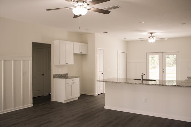 4350 Theresa St, Hastings, FL 32145 - kitchen featuring ceiling fan, light stone countertops, white cabinetry, dark wood-style floors, and a wainscoted wall
