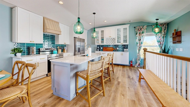 16/18/20 Inlet Pl, Saint Augustine, FL 32080 - kitchen with appliances with stainless steel finishes, custom exhaust hood, decorative backsplash, lofted ceiling, and light wood-type flooring