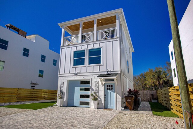 16/18/20 Inlet Pl, Saint Augustine, FL 32080 - view of front of property featuring board and batten siding, an attached garage, a balcony, fence, and decorative driveway