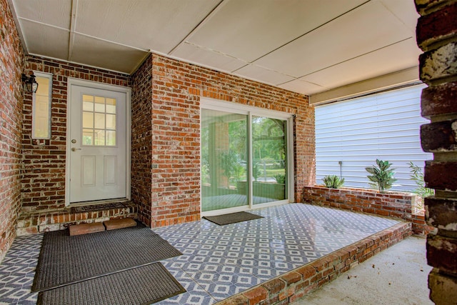 entrance to property featuring brick siding and a porch