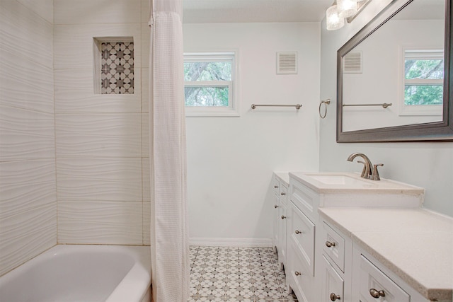 full bathroom featuring vanity, tile patterned floors, visible vents, and plenty of natural light