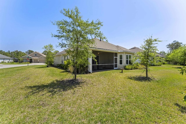 443 Pescado Dr, Saint Augustine, FL 32095 - back of property featuring a sunroom, concrete driveway, and a lawn