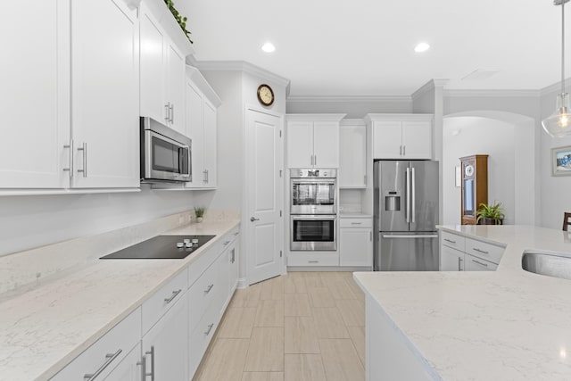443 Pescado Dr, Saint Augustine, FL 32095 - kitchen with arched walkways, crown molding, white cabinetry, light stone countertops, and stainless steel appliances