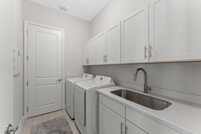 443 Pescado Dr, Saint Augustine, FL 32095 - laundry room with light wood-type flooring, visible vents, independent washer and dryer, cabinet space, and a sink