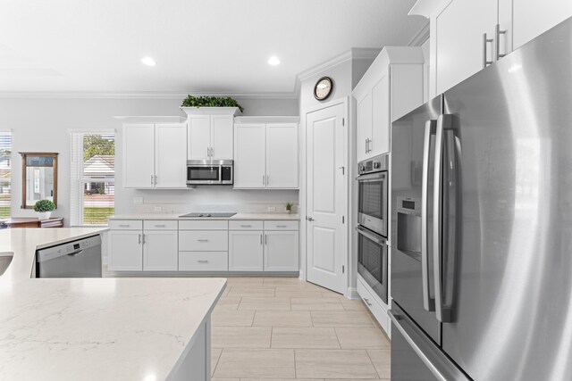 443 Pescado Dr, Saint Augustine, FL 32095 - kitchen with crown molding, white cabinets, appliances with stainless steel finishes, and light stone counters
