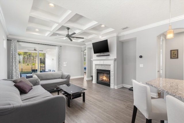 living room with hardwood / wood-style floors, beamed ceiling, ceiling fan, crown molding, and coffered ceiling