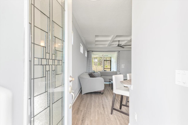 interior space with ceiling fan, beam ceiling, light wood-type flooring, and coffered ceiling