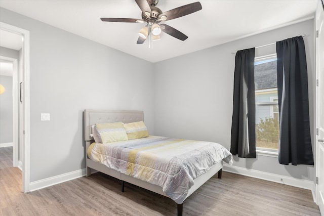 bedroom with ceiling fan and hardwood / wood-style flooring