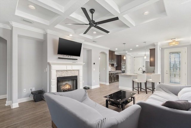 living room featuring ceiling fan, beam ceiling, and coffered ceiling