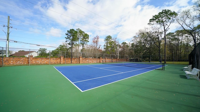 view of tennis court featuring fence