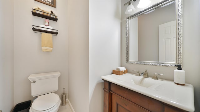 bathroom with vanity, toilet, and baseboards