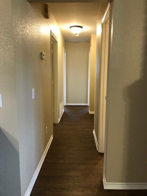 hallway with dark hardwood / wood-style floors