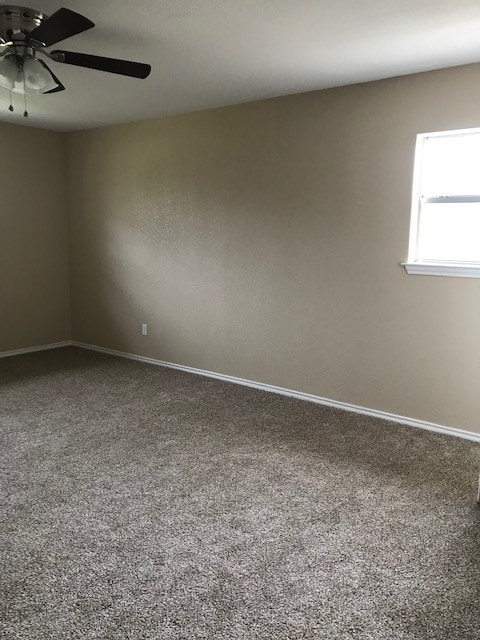 carpeted empty room featuring ceiling fan