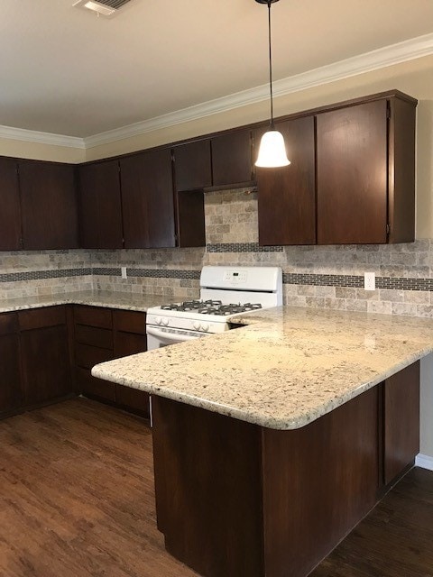 kitchen featuring dark hardwood / wood-style flooring, decorative light fixtures, tasteful backsplash, white range with gas stovetop, and light stone countertops