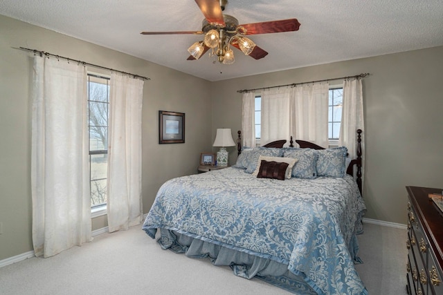 bedroom featuring ceiling fan, multiple windows, and light carpet