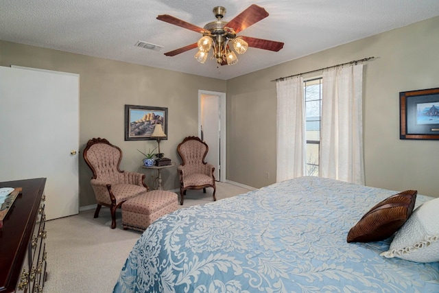 carpeted bedroom with ceiling fan and a textured ceiling