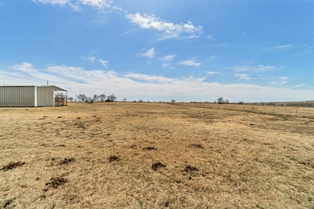 view of yard with an outdoor structure and a rural view