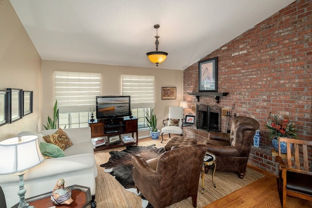 living room featuring lofted ceiling, a brick fireplace, brick wall, and hardwood / wood-style flooring