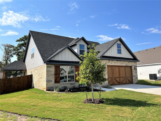 view of front facade featuring central AC unit, a front yard, and a garage