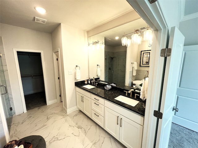 bathroom featuring a shower with door, tile floors, double sink, and vanity with extensive cabinet space