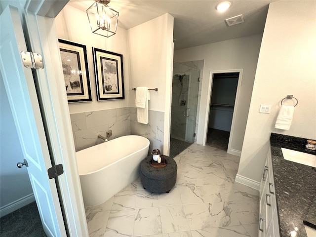 bathroom with an inviting chandelier, tile flooring, plus walk in shower, and vanity