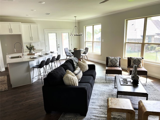 living room featuring crown molding, an inviting chandelier, hardwood / wood-style flooring, and french doors