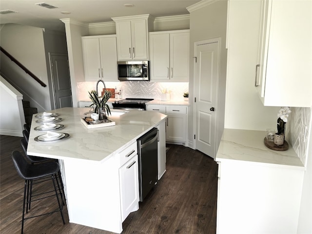 kitchen with white cabinets, dark hardwood / wood-style floors, a center island, and tasteful backsplash