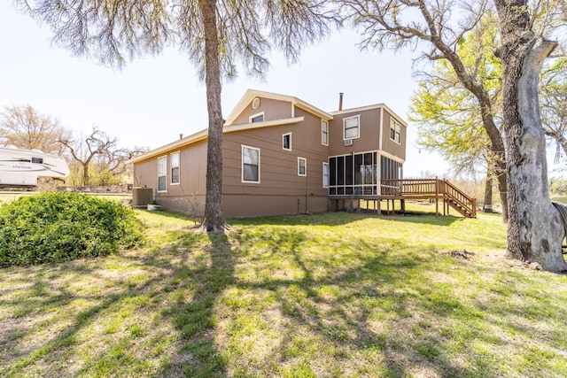 rear view of house featuring central AC and a yard