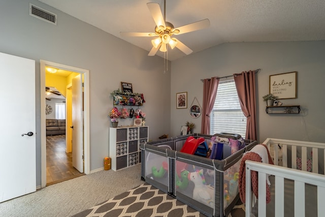 bedroom with a nursery area, light colored carpet, ceiling fan, and lofted ceiling