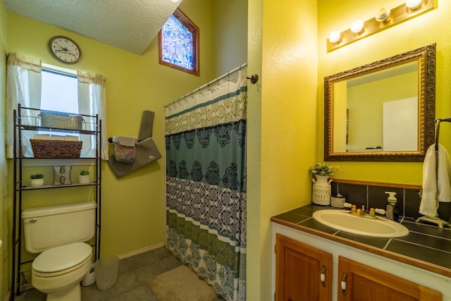 bathroom featuring toilet, a textured ceiling, vanity with extensive cabinet space, and tile flooring