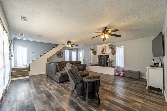 living room featuring ceiling fan, dark wood-type flooring, and a healthy amount of sunlight