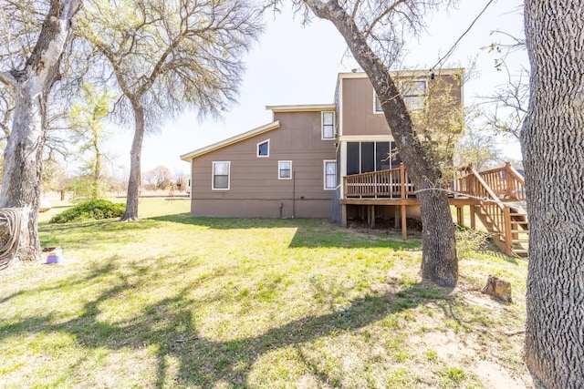 rear view of property with a deck and a yard