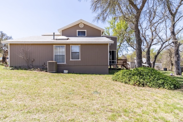 back of house with a yard and central air condition unit