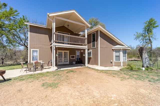 back of house featuring a balcony, french doors, and a patio