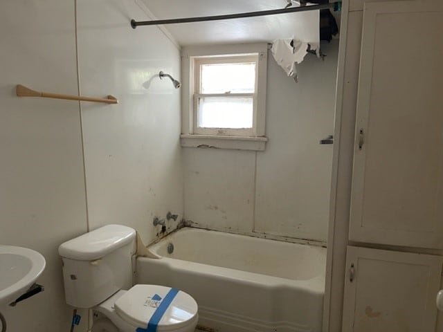 bathroom with shower / washtub combination and toilet