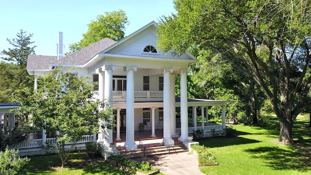 neoclassical home with a front lawn and a porch