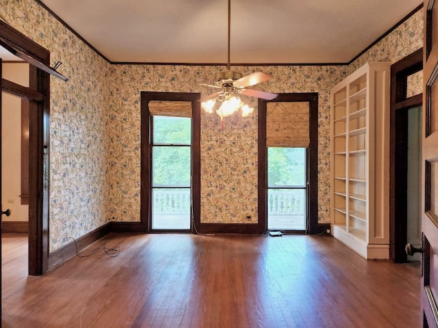 interior space featuring ceiling fan, a wealth of natural light, ornamental molding, and dark hardwood / wood-style floors