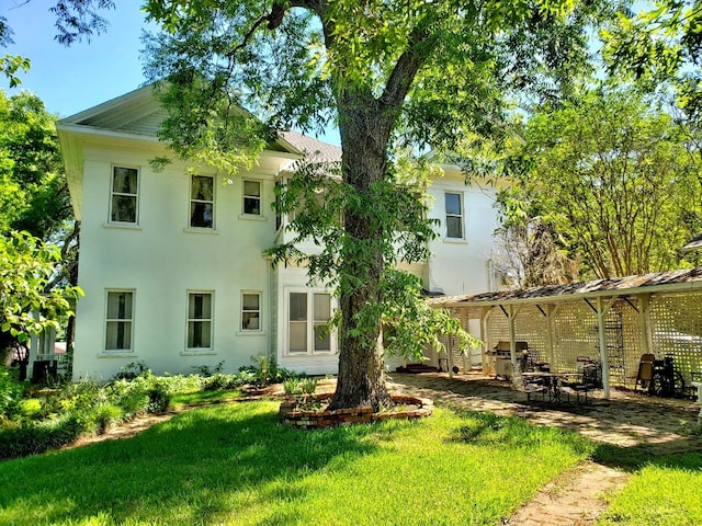 back of property with a lawn and a patio area