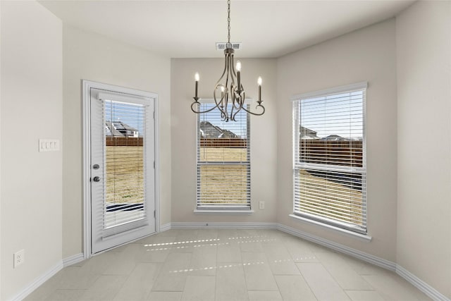 unfurnished dining area with a healthy amount of sunlight, a notable chandelier, and light tile flooring