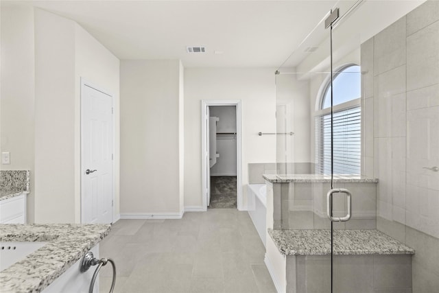 bathroom with independent shower and bath, tile flooring, and vanity