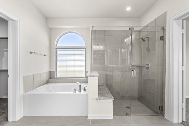 bathroom with tile floors and shower with separate bathtub