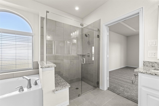 bathroom featuring tile flooring, independent shower and bath, and vanity