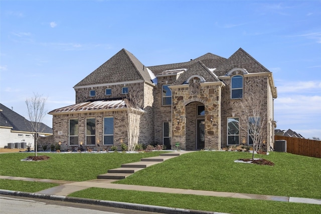 french country style house with central AC and a front lawn