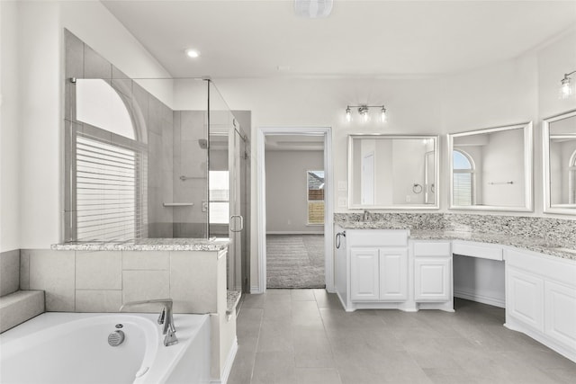 bathroom with plenty of natural light, vanity, and plus walk in shower