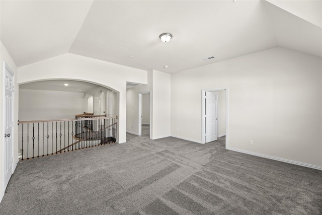 carpeted spare room featuring lofted ceiling