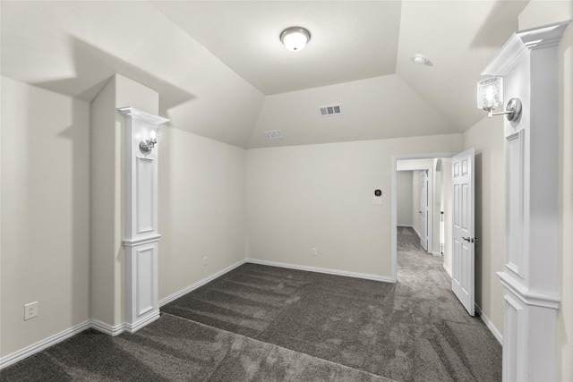 additional living space featuring dark colored carpet and lofted ceiling